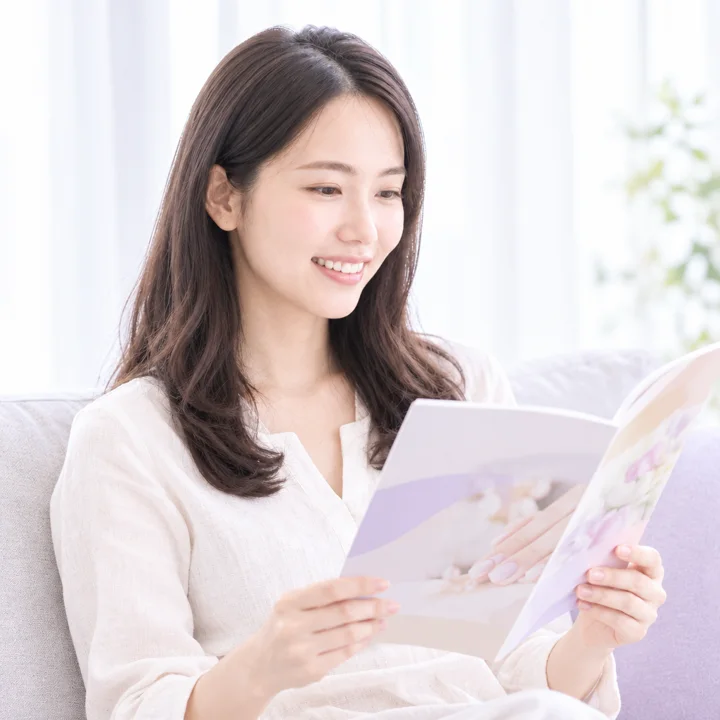 届いた冊子を読む見込み客